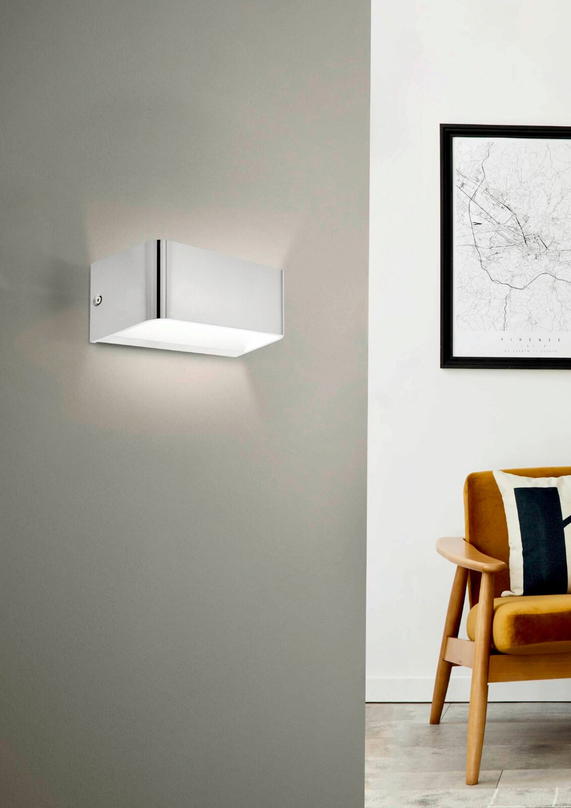 Moderne Wand- und Deckenleuchte SANIA 4 in rechteckiger Form, seitliche Perspektive, montiert an einer grauen Wand neben einem stilvollen Sessel und einem gerahmten Bild.