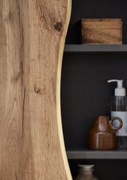 Nahaufnahme eines Unterschranks mit natürlicher Holzmaserung und Regalen mit Accessoires, seitliche Perspektive