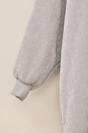 Nahaufnahme eines grauen Lounge Hoodies mit weichem Stoff und geripptem Bündchen, seitliche Perspektive