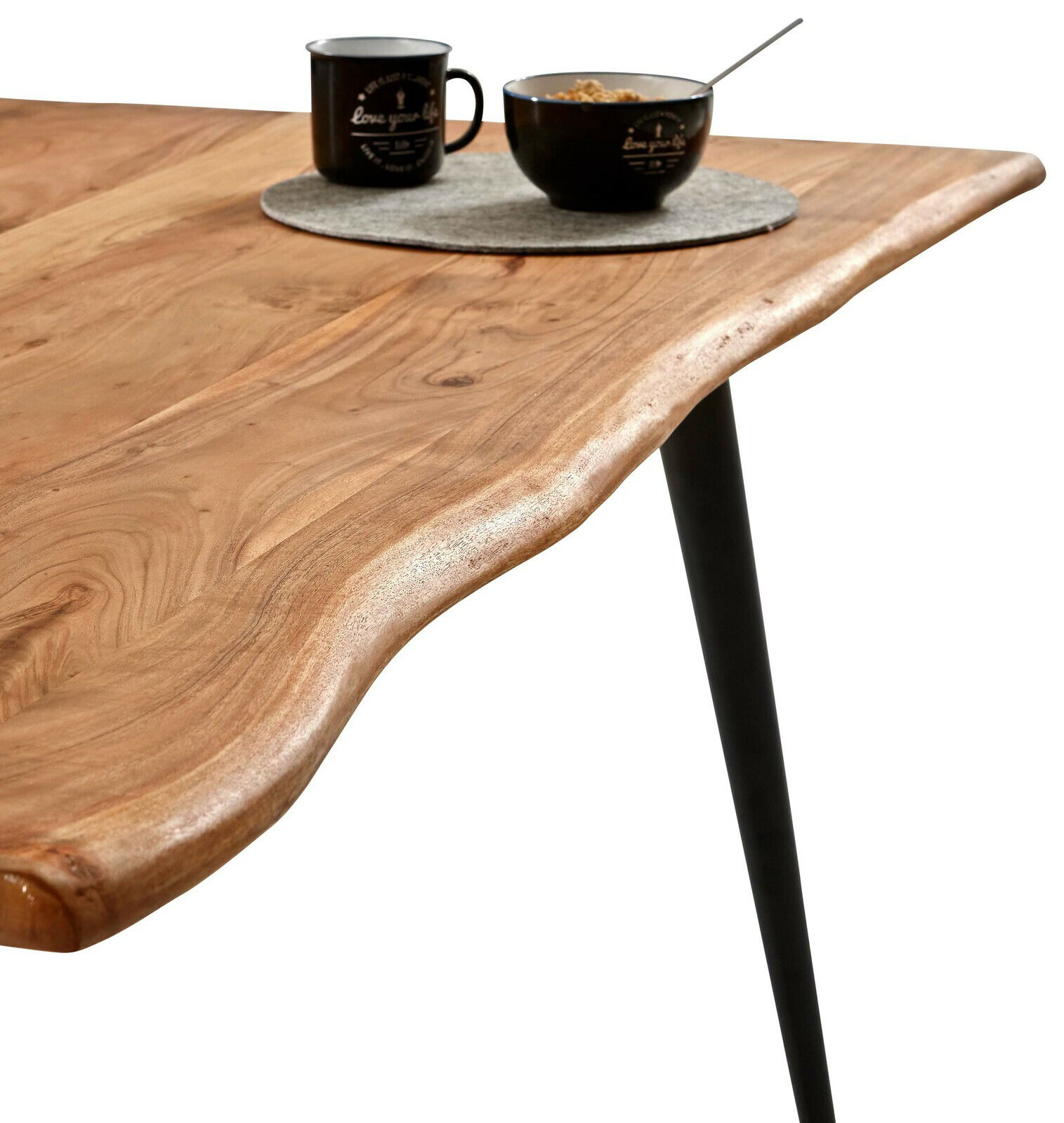 Nahaufnahme eines Esstisches mit natürlicher Holzmaserung und schwarzem Metallbein, von der Seite betrachtet.