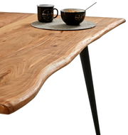 Nahaufnahme eines Esstisches mit natürlicher Holzmaserung und schwarzem Metallbein, von der Seite betrachtet.