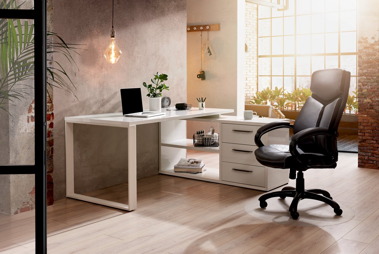 Moderner Eck-Schreibtisch in einem stilvollen Büro mit Lichteinfall von rechts, ausgestattet mit Laptop, Pflanzen und Büromaterialien.