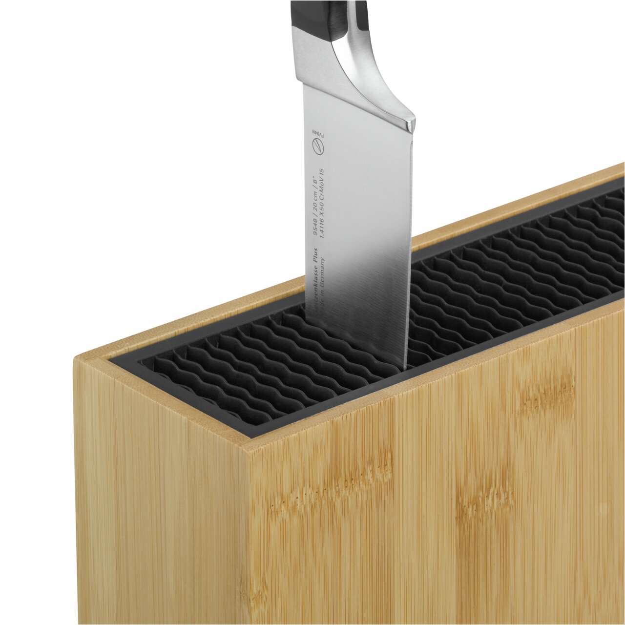 Nahaufnahme eines unbestückten Messerblocks aus Bambus mit einem Messer, das in den Block gesteckt ist, aus der Vogelperspektive.