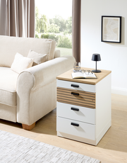 Rollcontainer GLENN in einem modernen Wohnzimmer, seitliche Perspektive, mit Holz- und weißen Elementen, neben einem Sofa platziert.