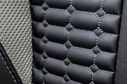 Nahaufnahme der Polsterung eines Gaming-Stuhls mit schwarzem Kunstleder und grauem Netzstoff.