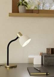 Moderne Tischleuchte MACERE in seitlicher Perspektive auf einem Schreibtisch, mit schwarzem Ständer und weißem Lampenschirm, umgeben von Büroaccessoires.