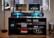 Gaming-Schreibtisch mit zwei Monitoren, Tastatur, Maus und Kopfhörern, beleuchtet von blauen LEDs, in einem modernen Raum mit Stadtblick.