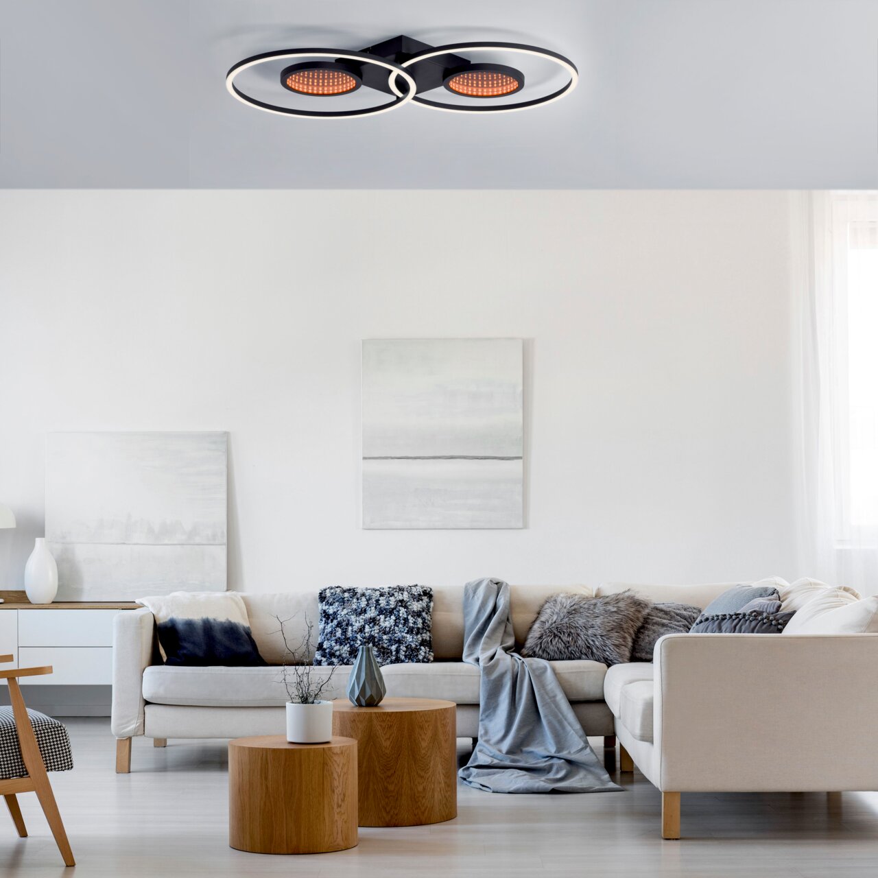 Moderne plafondlamp TUNEL in een stijlvolle woonkamer, van onderaf gezien. De lamp bestaat uit twee ronde, zwarte elementen met verlichte led-ringen.