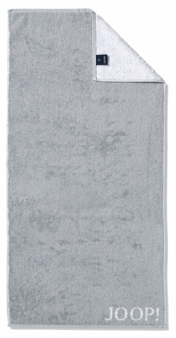 Graues Handtuch mit eingewebtem 'JOOP!' Logo, von oben fotografiert, mit umgeschlagener Ecke, die die weiße Rückseite zeigt.