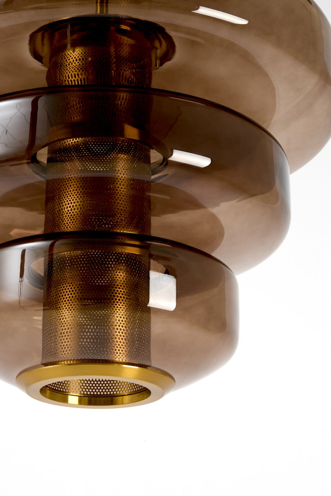 Close-up vanuit onderaanzicht van een moderne hanglamp met drie rookbruine glazen kappen en een goudkleurige, geperforeerde metalen kern.
