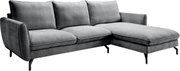 Graues L-förmiges Ecksofa mit Recamiere rechts, drei Rückenkissen, breiten Armlehnen und schwarzen Metallfüßen, in schräger Frontansicht von links auf weißem Hintergrund.