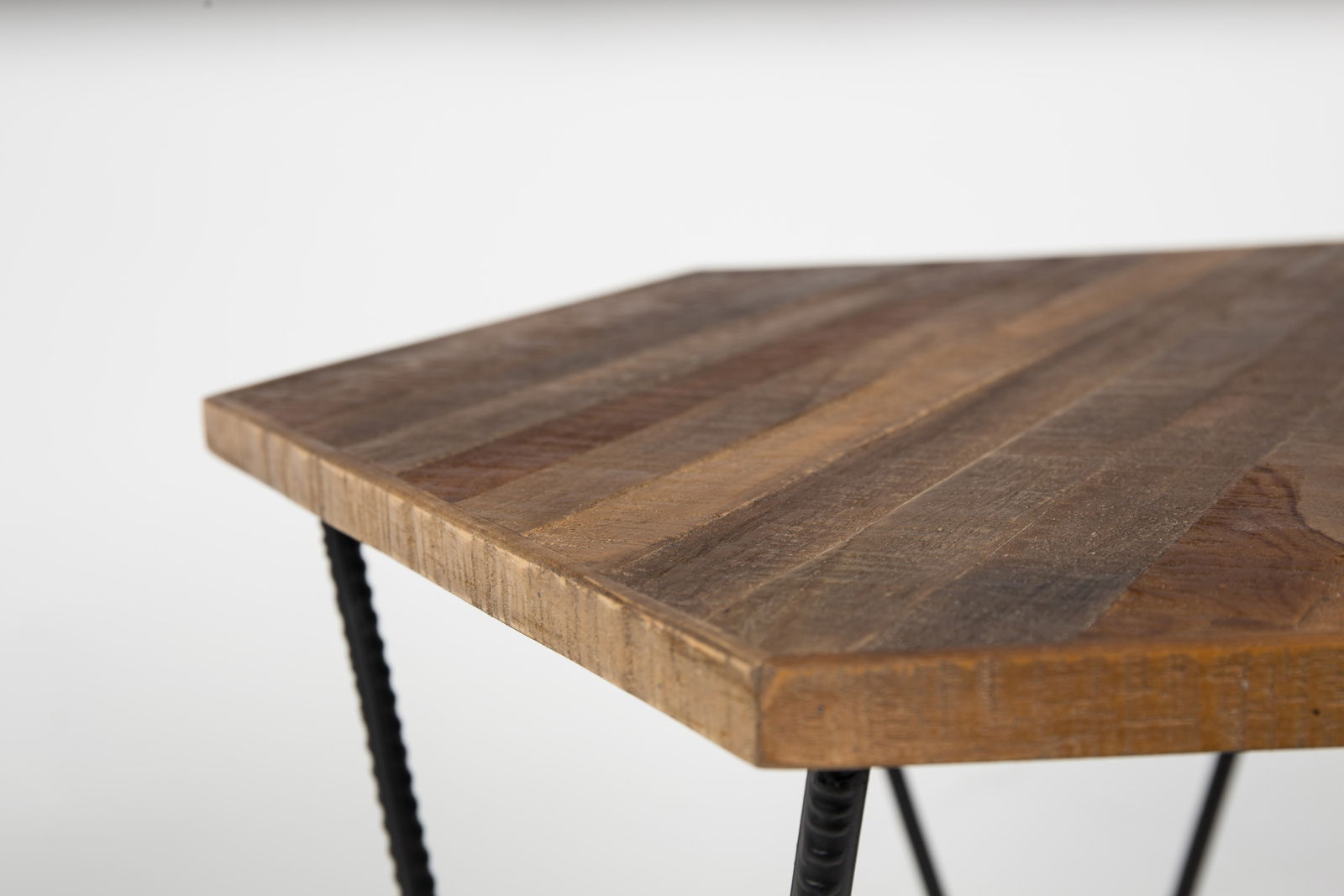 Nahaufnahme eines Beistelltisches mit einer Tischplatte aus Holz und schwarzen Metallbeinen, Perspektive von oben.