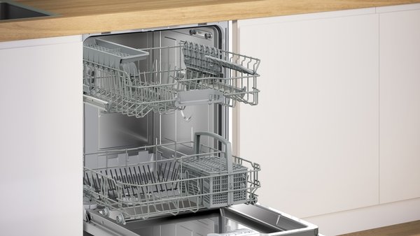 Einbaugeschirrspüler mit geöffneter Tür, Blick von vorne auf die herausgezogenen Geschirrkörbe.