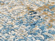 Nahaufnahme eines Designer Teppichs mit abstraktem Muster in Blau-, Beige- und Grautönen, von oben betrachtet.