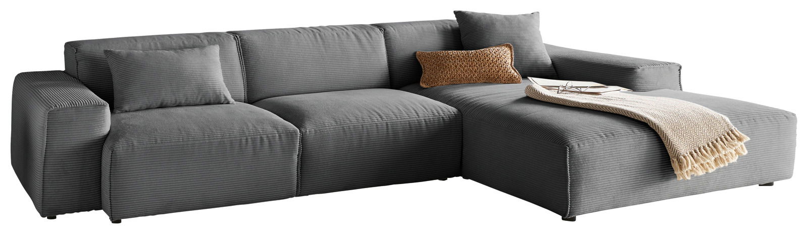 Lounge Handmade Ecksofa LH-EDINA Graues Ecksofa mit Ottomane, dekoriert mit Kissen und Decke, Perspektive von vorne.