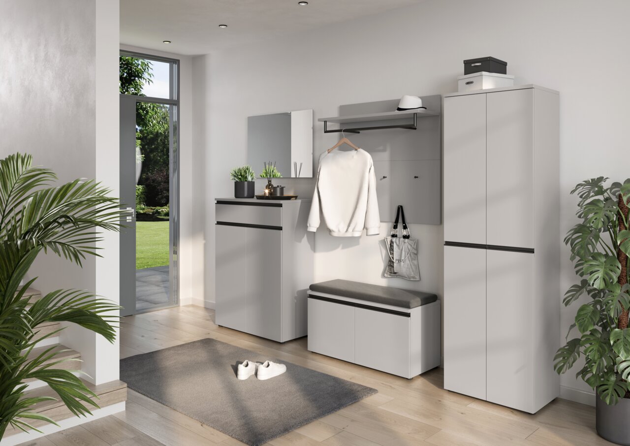 Moderne Garderobeneinrichtung mit Schuhschrank, Spiegel, Schuhbank, Garderobenpaneel und Garderobenschrank in einem hellen Raum mit Blick auf den Garten.