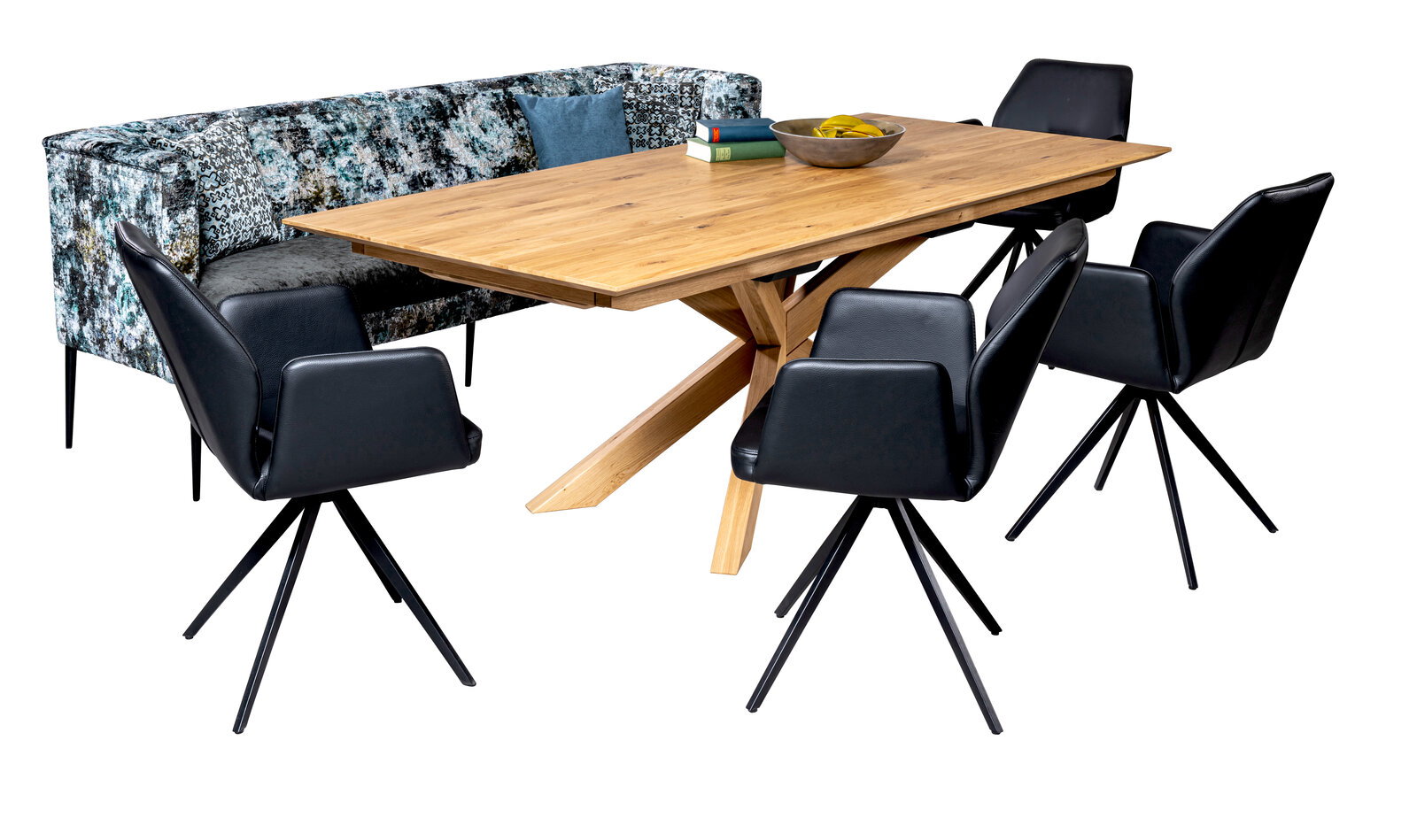 Moderner Esstisch aus Holz mit X-förmigem Gestell, umgeben von schwarzen Stühlen und einer gemusterten Bank, aus seitlicher Perspektive.
