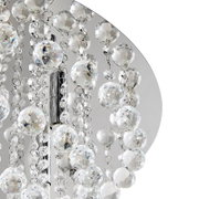 Close-up van een elegante plafondlamp met schitterende kristallen hangers, gezien van onderaf.