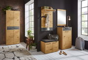 Moderner Eingangsbereich mit Sitzkissen auf einem Holzschrank, umgeben von Pflanzen und Dekorationen, seitliche Perspektive.