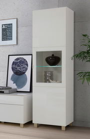 Weiße Vitrine mit Glaseinsatz, frontal fotografiert, dekoriert mit Vasen und Pflanzen.