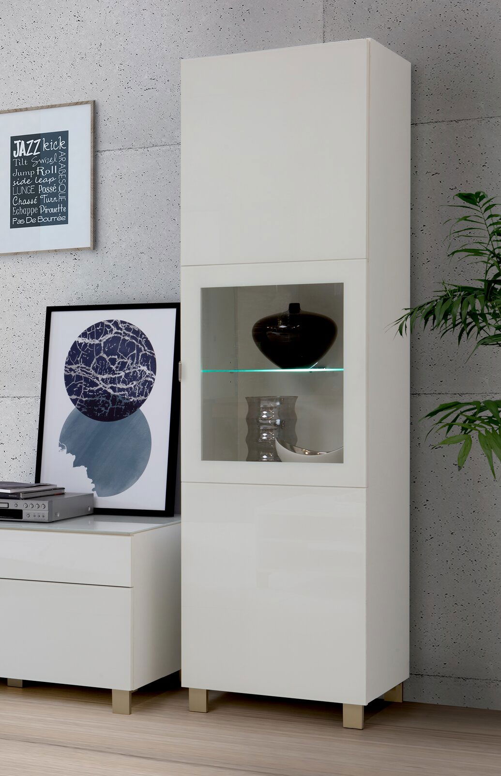 Weiße Vitrine mit Glaseinsatz, frontal fotografiert, dekoriert mit Vasen und Pflanzen.