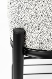 Nahaufnahme einer Sitzbank mit schwarzem Metallrahmen und grauem, strukturiertem Stoffbezug, seitliche Perspektive.