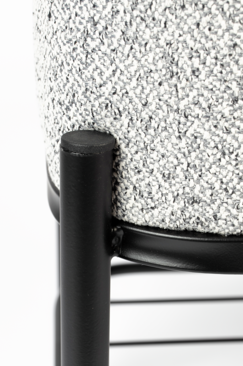 Nahaufnahme einer Sitzbank mit schwarzem Metallrahmen und grauem, strukturiertem Stoffbezug, seitliche Perspektive.