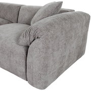 Graues Sofa mit abgerundeten Ecken und Kissen, seitliche Perspektive