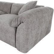 Graues Sofa mit abgerundeten Ecken und Kissen, seitliche Perspektive