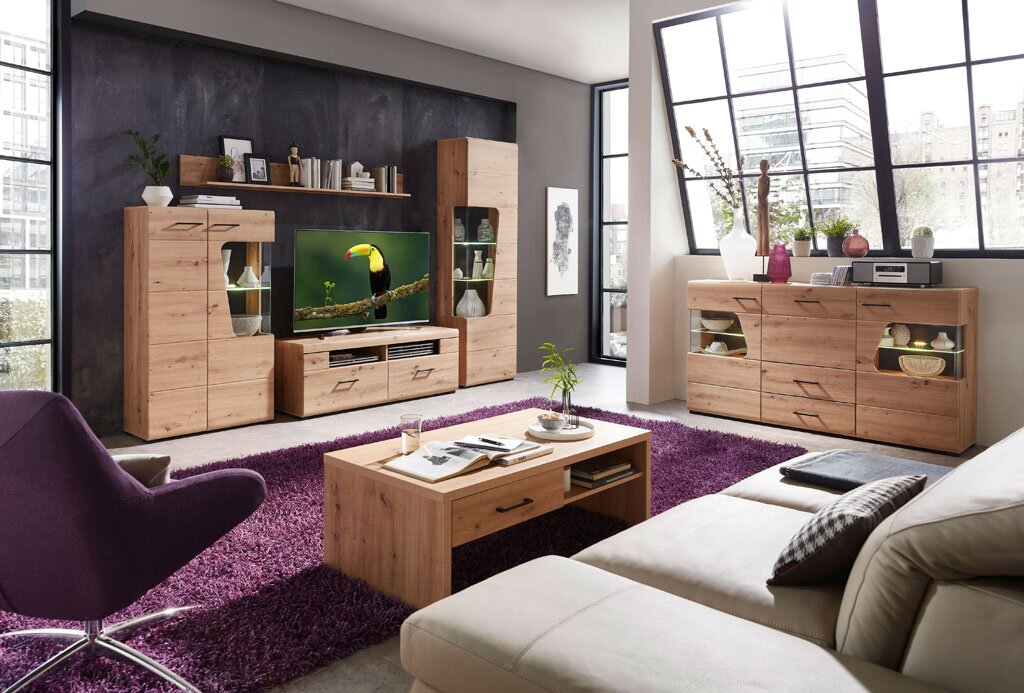 Moderne Wohnwand mit Sideboard und Couchtisch aus Holz in einem hellen Wohnzimmer mit großen Fenstern, seitliche Perspektive.