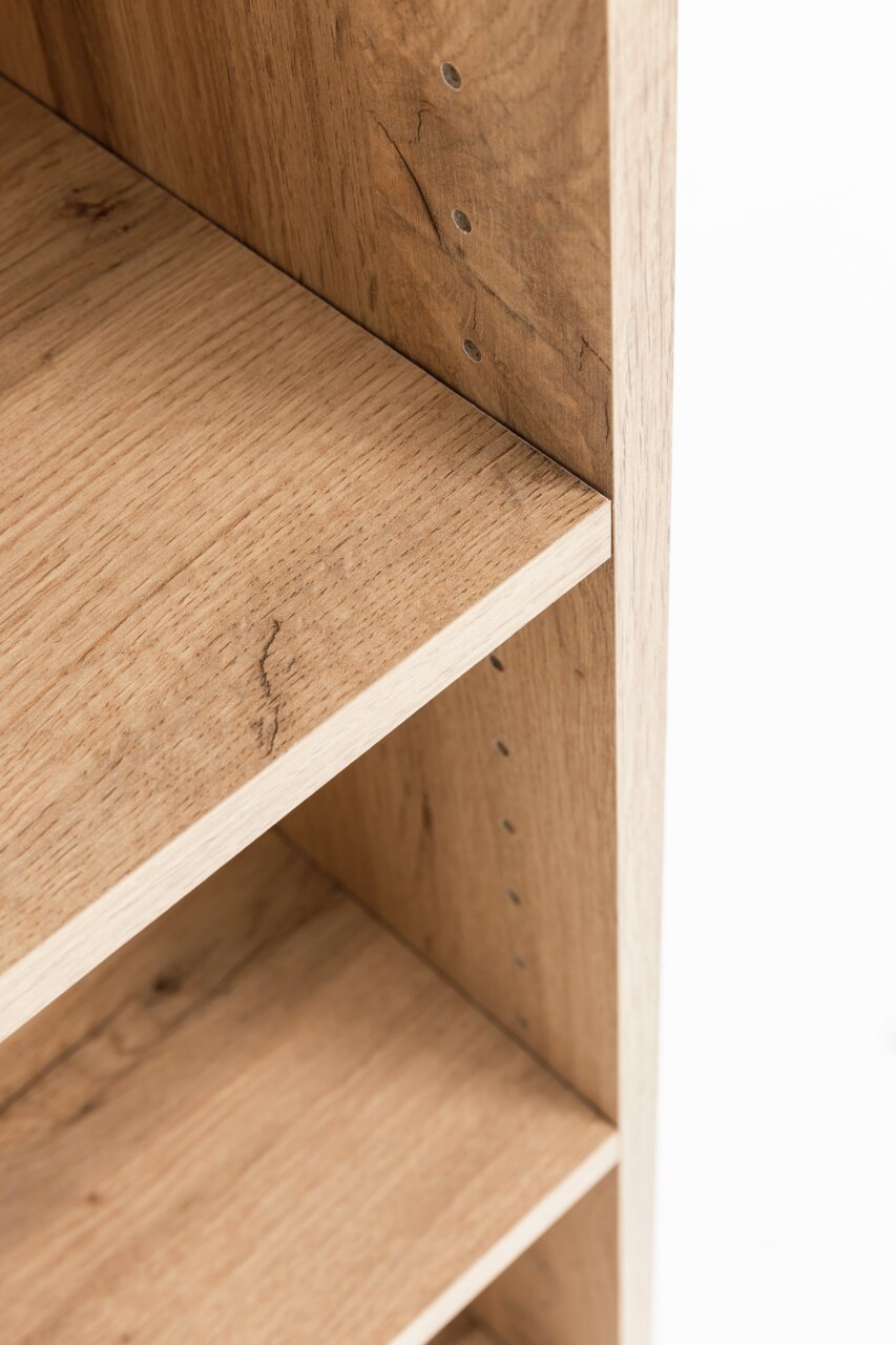 Nahaufnahme eines Midischranks aus Holz mit verstellbaren Regalböden, seitliche Perspektive.