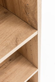 Nahaufnahme eines Midischranks aus Holz mit verstellbaren Regalböden, seitliche Perspektive.