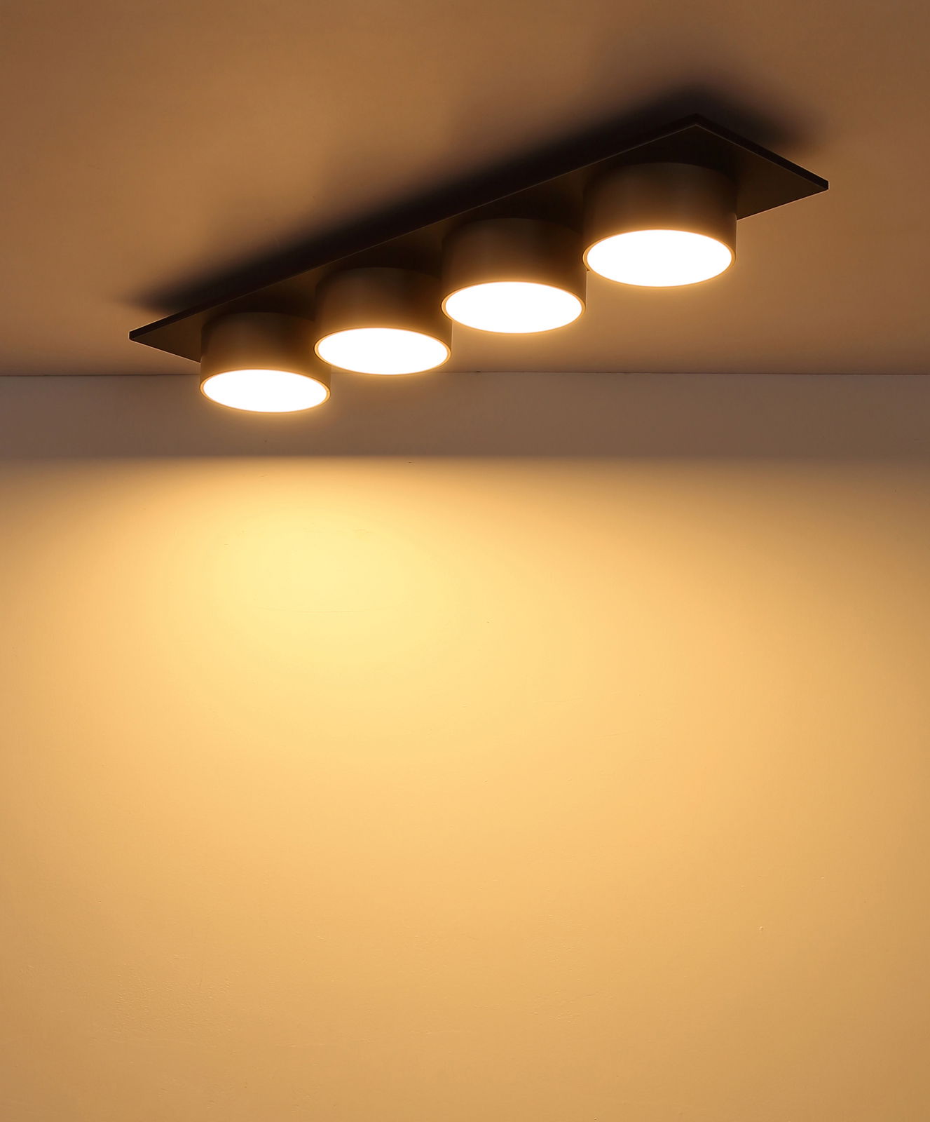 Moderne Deckenleuchte mit vier runden, leuchtenden Spots, seitliche Perspektive