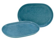 Zwei ovale, türkisfarbene Keramik-Servierplatten mit geprägtem Mandala-Ornament, eine liegend und eine aufrecht im Hintergrund, Produktansicht leicht schräg von vorn