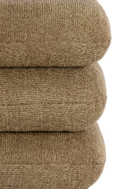 Seitliche Nahaufnahme eines weich gepolsterten Möbelstücks mit drei abgerundeten, übereinanderliegenden Polsterelementen und strukturiertem Bezug in warmem Beige.