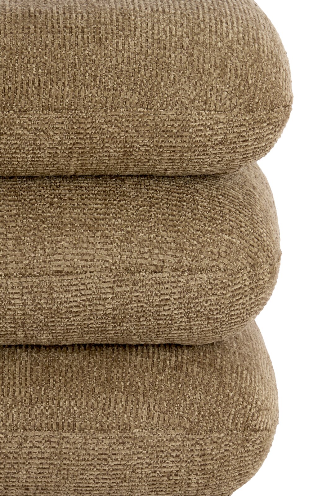 Seitliche Nahaufnahme eines weich gepolsterten Möbelstücks mit drei abgerundeten, übereinanderliegenden Polsterelementen und strukturiertem Bezug in warmem Beige.