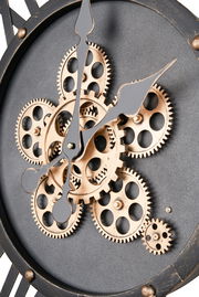 Nahaufnahme einer Wanduhr mit sichtbaren Zahnrädern und schwarzen Zeigern, seitliche Perspektive.