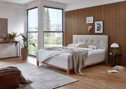 Modernes Polsterbett in einem stilvollen Schlafzimmer mit Holzvertäfelung und großen Fenstern, seitliche Perspektive.
