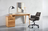 Moderner Schreibtisch aus Holz mit Schubladen, darauf eine schwarze Lampe und Dekoration. Daneben steht ein gepolsterter Bürostuhl auf Rollen. Perspektive: Frontalansicht.