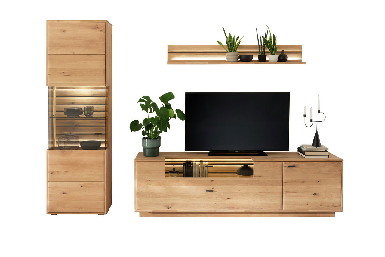 Wandkombination aus Holz mit TV-Schrank, Vitrine und Regal, dekoriert mit Pflanzen und Kerzen, Frontalansicht