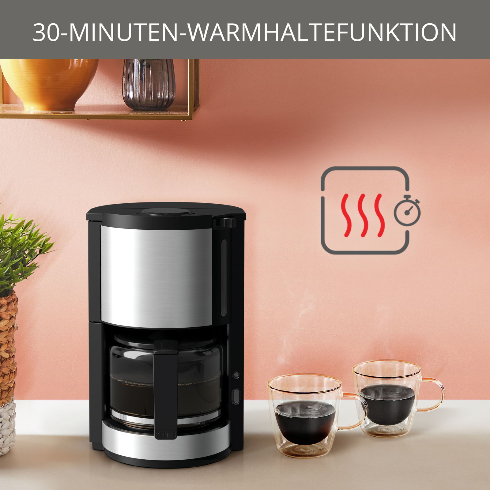 Kaffeemaschine ProAroma Plus mit 30-Minuten-Warmhaltefunktion, frontal abgebildet neben zwei dampfenden Kaffeetassen.