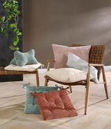 Sitzkissen in verschiedenen Farben auf einem Holzstuhl und Boden, seitliche Perspektive