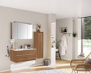 Moderner Badezimmer-Mittelschrank in Holzoptik, rechts an der Wand montiert, mit seitlicher Perspektive.