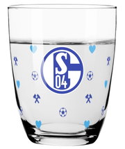 Transparentes Trinkglas mit blauem FC-Schalke-04-Logo sowie Fußball-, Herz- und Schlägel-und-Eisen-Motiven, frontal aus leichter Draufsicht dargestellt