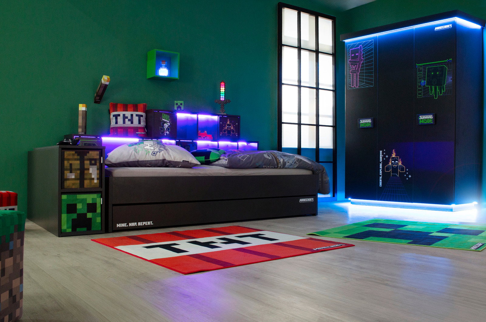 Zurbrüggen Kleiderschrank 3-türig MINECRAFT Kinderzimmer mit Gaming-Thema, zeigt einen dreitürigen Kleiderschrank mit leuchtenden Grafiken und ein Bett mit thematischer Bettwäsche, seitliche Perspektive.