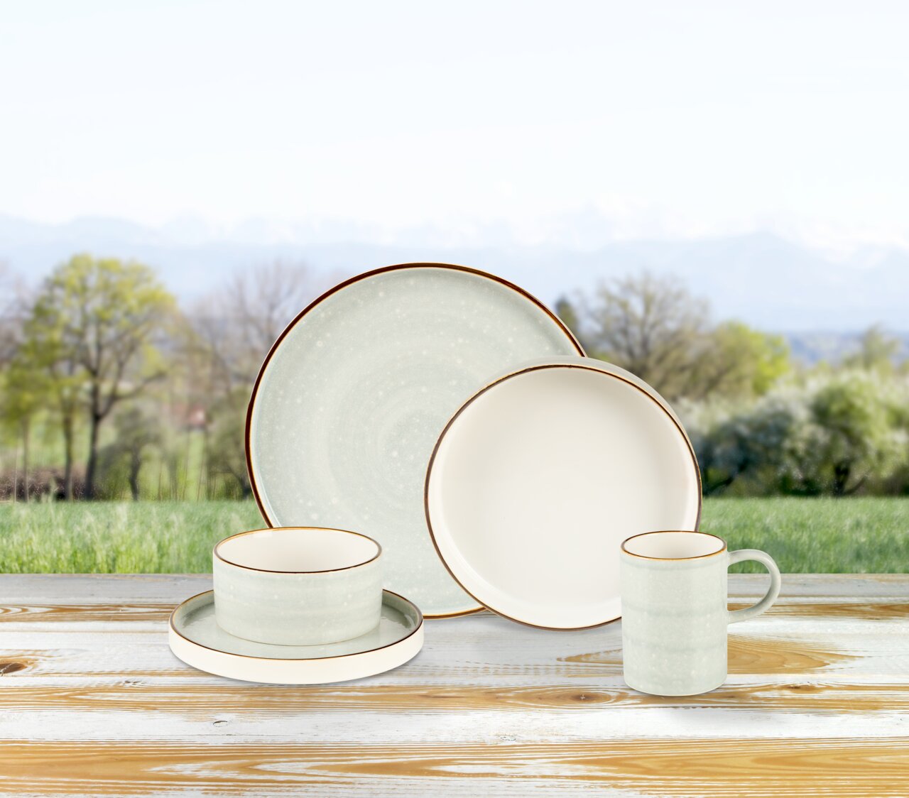 Kombiservice 10-tlg. in natürlicher Umgebung, bestehend aus Tellern, Tasse und Schale, auf einem Holztisch präsentiert.