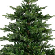 Nahaufnahme eines künstlichen Weihnachtsbaums mit dichten, grünen Zweigen, perspektivisch von der Seite aufgenommen.