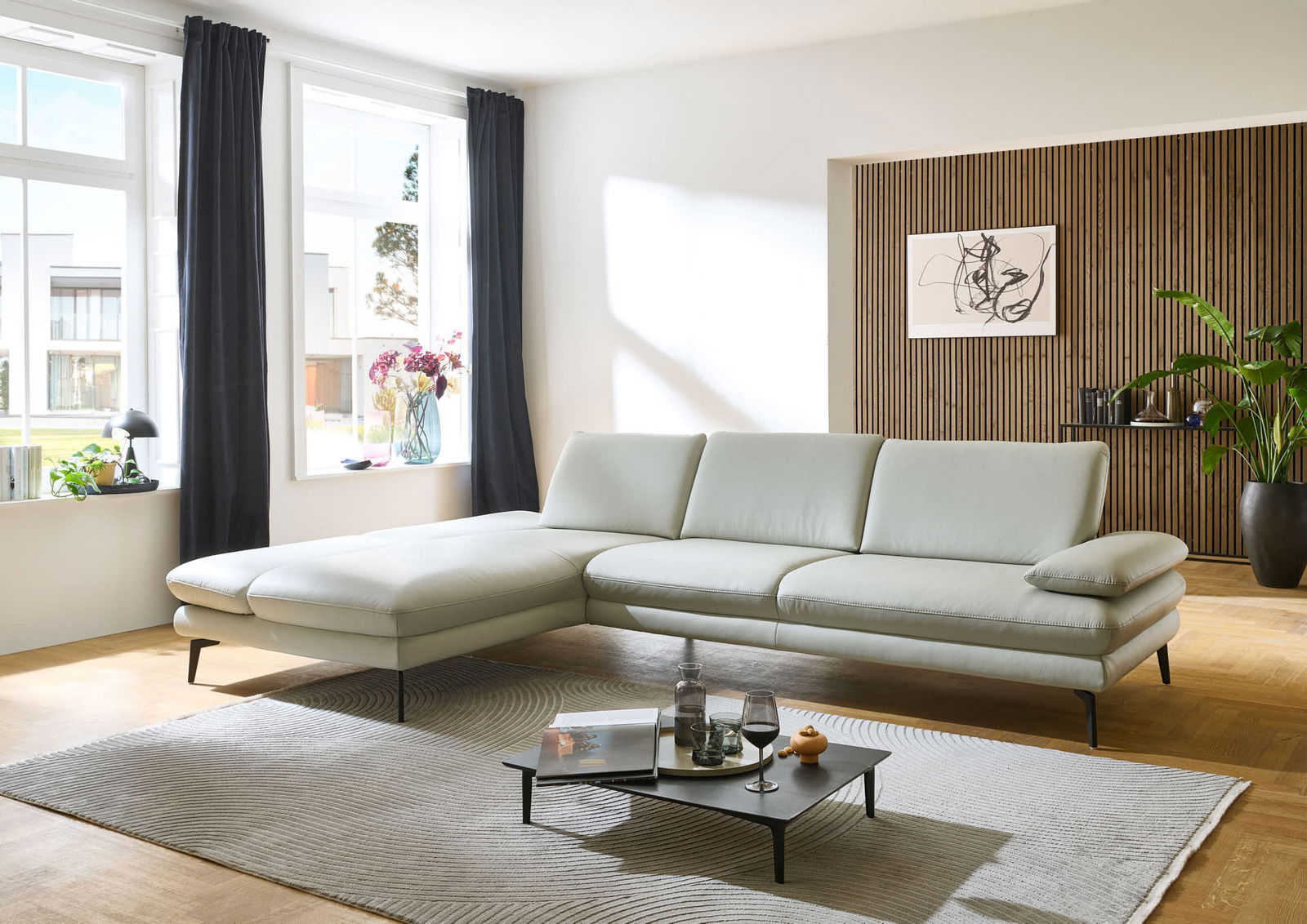 Moderne Longchairkombination in einem hellen Wohnzimmer, seitliche Perspektive