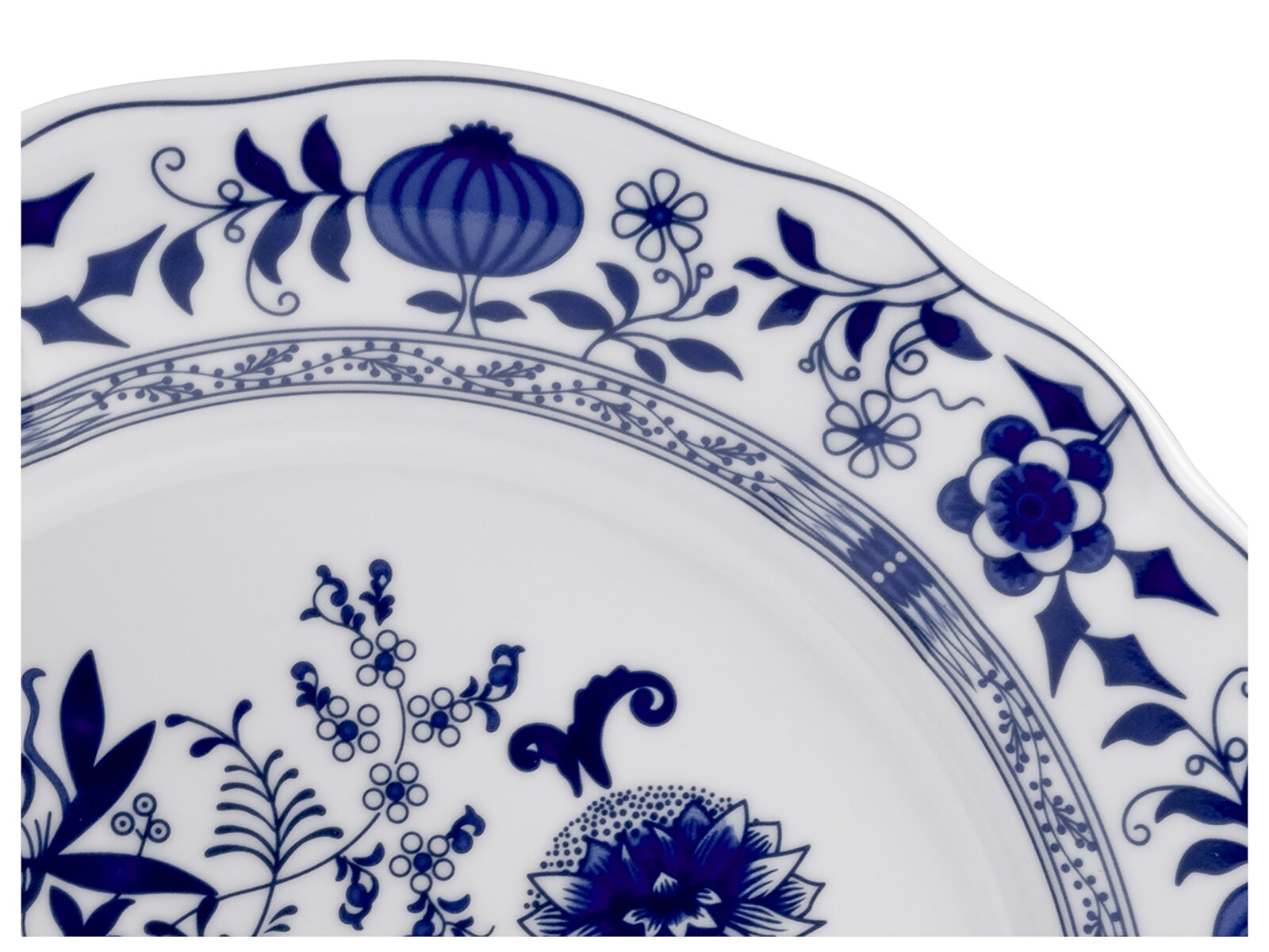 Nahaufnahme eines weißen Porzellantellers mit blauem floralem Dekor am wellenförmigen Rand, fotografiert in schräger Draufsicht (Detailansicht).