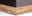 Nahaufnahme der Ecke eines Boxspringbetts mit Holzrahmen und dunklem Stoffbezug, seitliche Perspektive